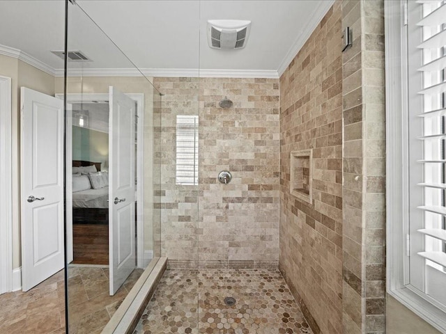 bathroom featuring ornamental molding and tiled shower