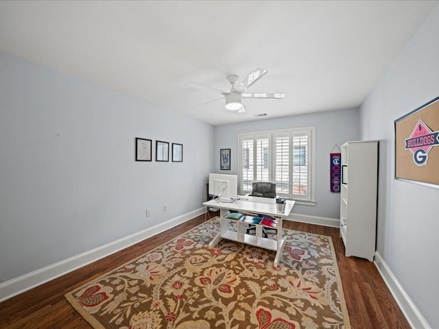 home office with dark wood-type flooring and ceiling fan