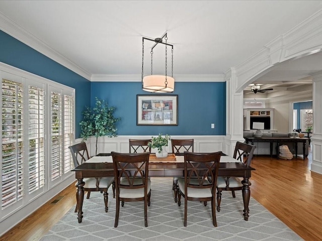 dining area featuring ornamental molding, ceiling fan, and light wood-type flooring