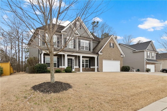 view of front of home featuring a front yard, concrete driveway, covered porch, and a garage