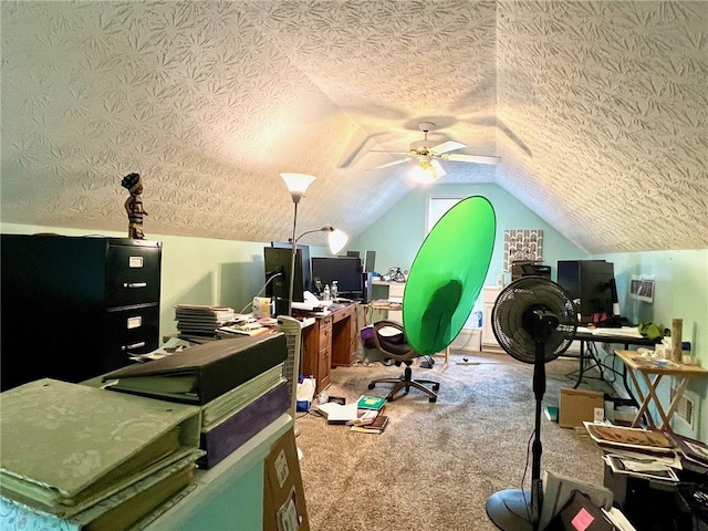 office space with ceiling fan, vaulted ceiling, carpet, and a textured ceiling