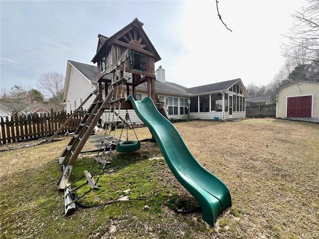 view of playground featuring a storage unit, a yard, and a sunroom