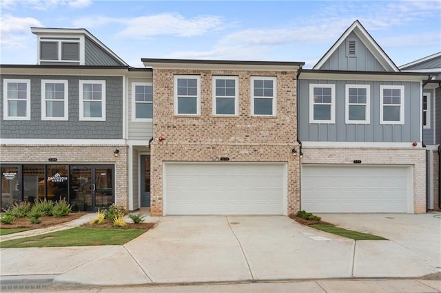 multi unit property featuring brick siding, board and batten siding, concrete driveway, and an attached garage