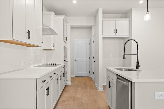 kitchen featuring white cabinetry, stainless steel appliances, light countertops, and a sink