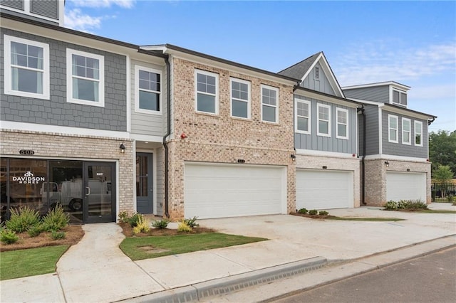 townhome / multi-family property featuring brick siding, board and batten siding, and an attached garage