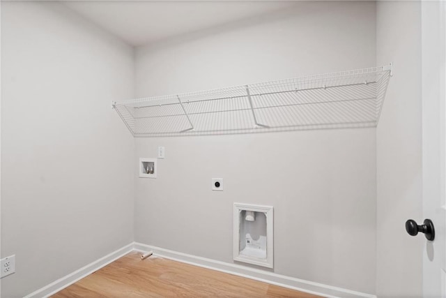 clothes washing area featuring electric dryer hookup, light wood-type flooring, washer hookup, baseboards, and laundry area