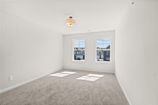 spare room featuring baseboards and carpet floors