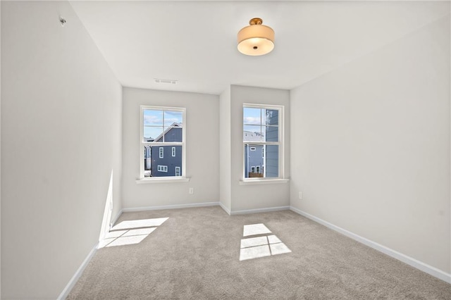 spare room featuring visible vents, baseboards, and carpet