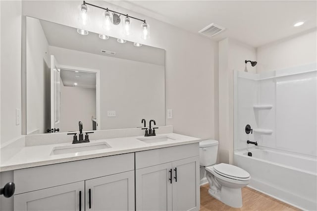 full bathroom with double vanity, toilet, visible vents, and a sink