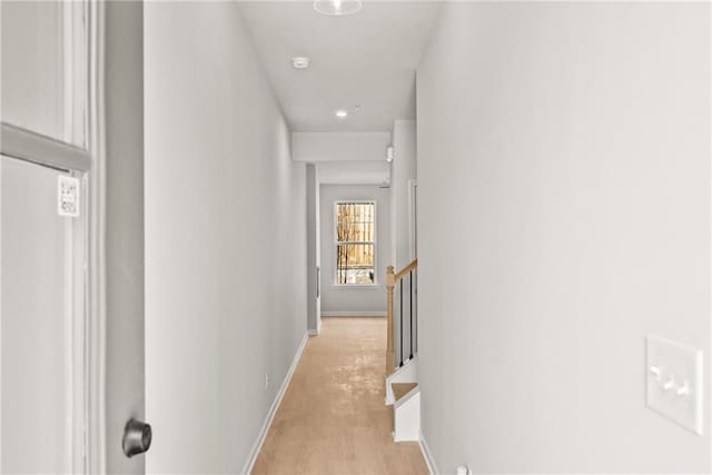 hall with baseboards and light wood-type flooring