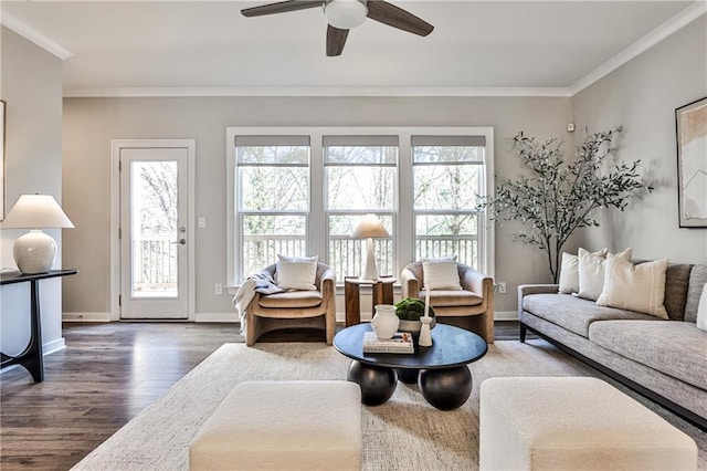 living room with wood finished floors, crown molding, a ceiling fan, and baseboards
