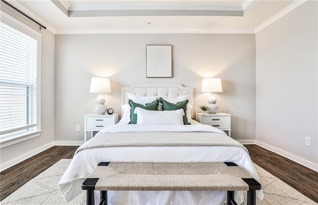 bedroom with crown molding, baseboards, dark wood-type flooring, and a raised ceiling