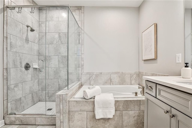 bathroom with vanity, a garden tub, and a stall shower