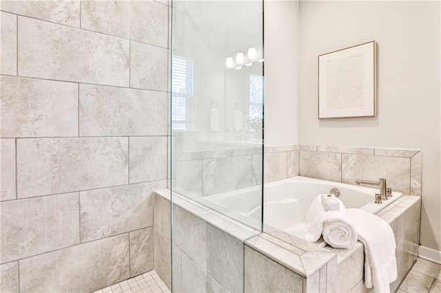 bathroom with a garden tub and a tile shower