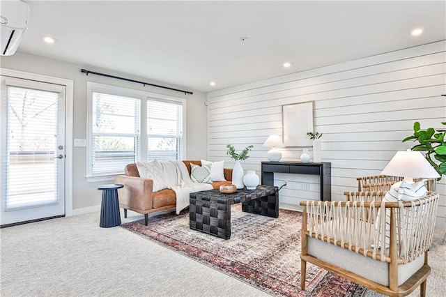 living room featuring wooden walls, carpet, baseboards, recessed lighting, and an AC wall unit