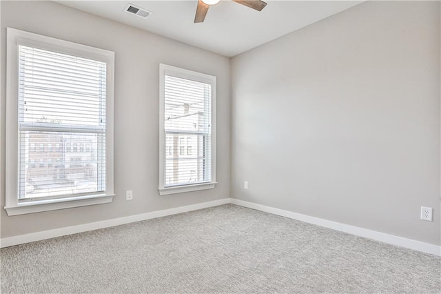 unfurnished room with visible vents, baseboards, carpet, and ceiling fan