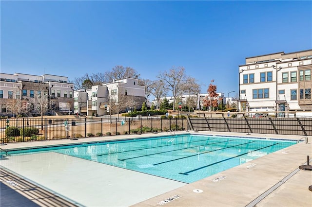 community pool featuring fence and a residential view