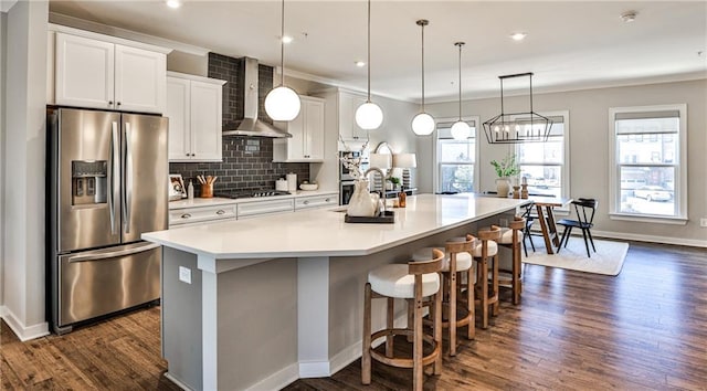 kitchen featuring cooktop, a large island, decorative backsplash, wall chimney range hood, and stainless steel fridge