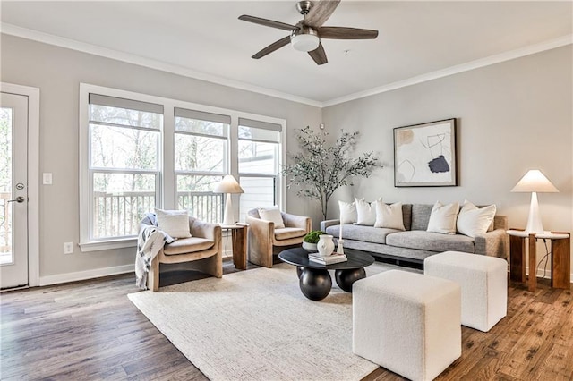 living room with plenty of natural light, crown molding, baseboards, and wood finished floors