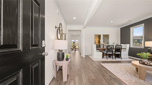 foyer entrance with light wood-type flooring and crown molding