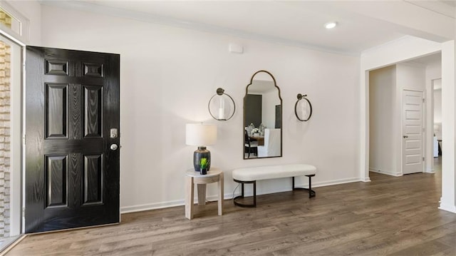 foyer entrance with dark hardwood / wood-style flooring and crown molding