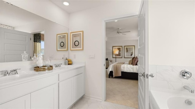 bathroom with a tub, ceiling fan, and vanity