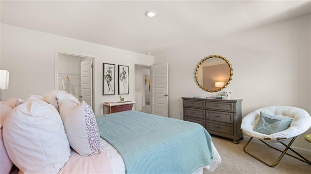 bedroom with light carpet, a walk in closet, and a closet