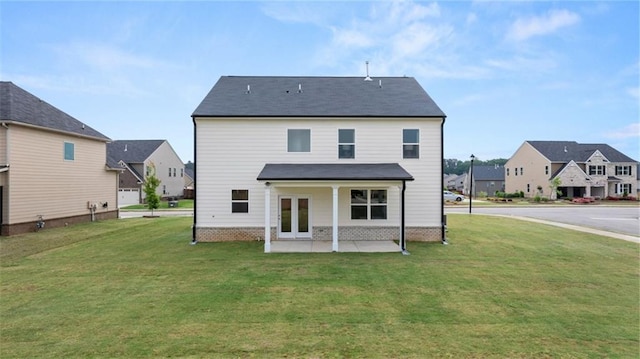 rear view of property with a yard and a patio