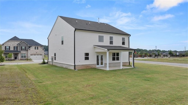 rear view of house with a garage and a yard