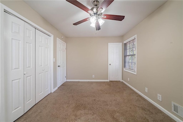 unfurnished bedroom with ceiling fan, multiple closets, and carpet