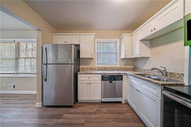 kitchen with appliances with stainless steel finishes, white cabinets, and light stone counters