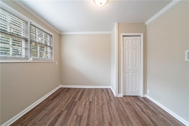 empty room featuring crown molding and hardwood / wood-style flooring