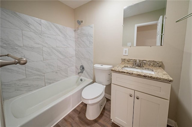 full bathroom with hardwood / wood-style flooring, tiled shower / bath combo, vanity, and toilet