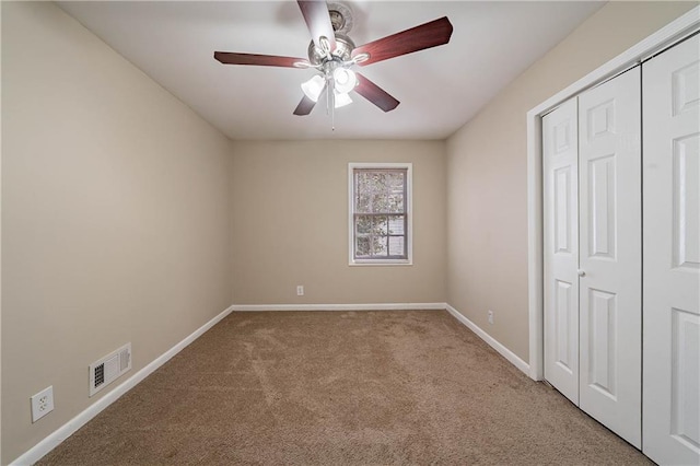 unfurnished bedroom with ceiling fan, a closet, and light colored carpet