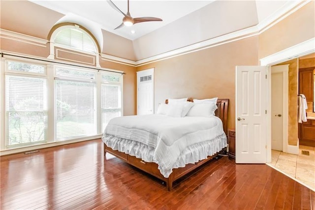 bedroom with ceiling fan, wood-type flooring, and a high ceiling