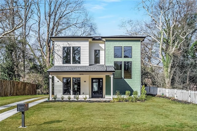 view of front of home featuring fence and a front lawn