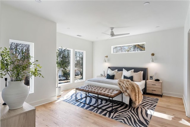 bedroom featuring ceiling fan, light wood-style flooring, and baseboards
