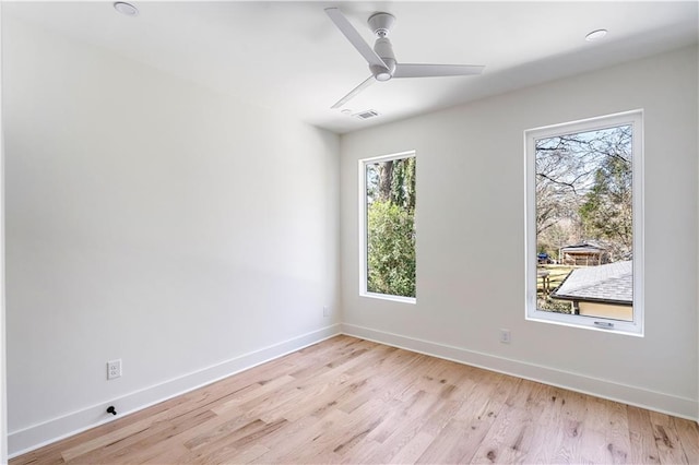 spare room with visible vents, ceiling fan, light wood-style flooring, and baseboards
