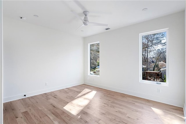unfurnished room with light wood-style flooring, visible vents, baseboards, and a ceiling fan