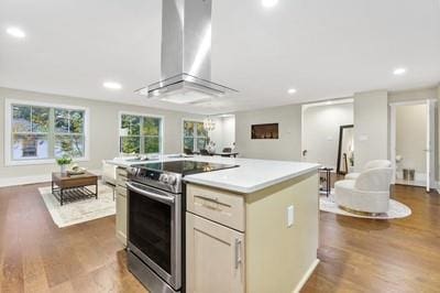 kitchen featuring stainless steel electric range oven, wall chimney range hood, a kitchen island, dark hardwood / wood-style floors, and white cabinets