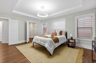 bedroom with hardwood / wood-style floors and a raised ceiling