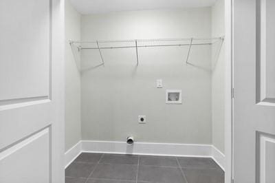 laundry area featuring hookup for an electric dryer, dark tile patterned floors, and hookup for a washing machine