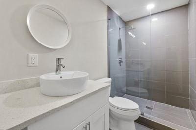 bathroom featuring vanity, toilet, and a shower with shower door