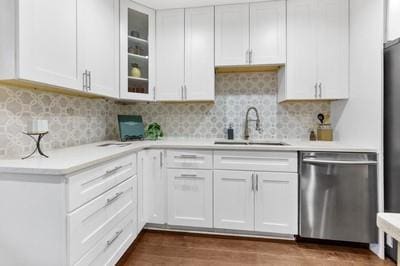 kitchen featuring white cabinets, backsplash, and stainless steel dishwasher