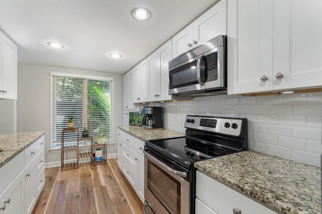 46 Ivy Rdg NE, Atlanta, GA 30342 - kitchen with appliances with stainless steel finishes, light wood-type flooring, baseboards, white cabinetry, and recessed lighting