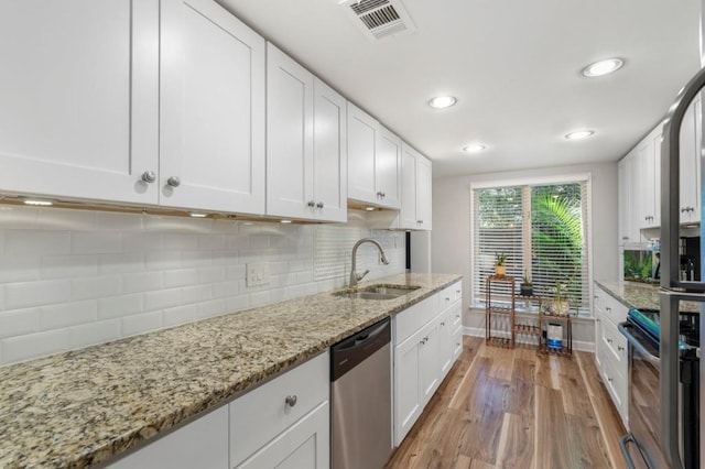 46 Ivy Rdg NE, Atlanta, GA 30342 - kitchen with stainless steel dishwasher, a sink, light wood-style flooring, white cabinets, and recessed lighting