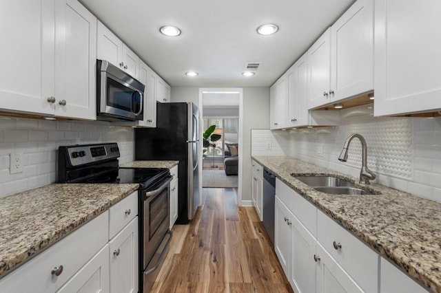 46 Ivy Rdg NE, Atlanta, GA 30342 - kitchen with stainless steel appliances, a sink, light wood finished floors, white cabinetry, and recessed lighting