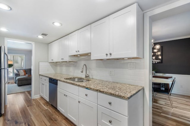 46 Ivy Rdg NE, Atlanta, GA 30342 - kitchen featuring appliances with stainless steel finishes, a sink, wood finished floors, white cabinetry, and ornamental molding