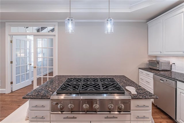 kitchen with ornamental molding, wood finished floors, appliances with stainless steel finishes, a toaster, and a raised ceiling