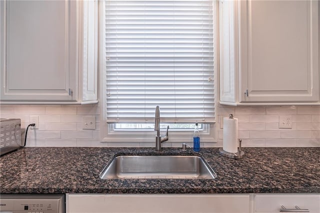 kitchen featuring white cabinetry, backsplash, and a sink